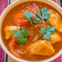 Traditionelles nordindisches Curry mit Poulet in Tomatensauce, serviert in Kupferschale – India4U Bern