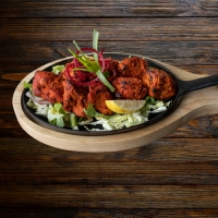 Tandoori-gegrillte Lammstücke in Joghurt-Gewürz-Marinade – serviert bei India4U Bern